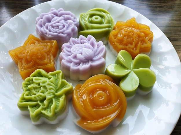 Foto fiori tradizionali tailandesi della gelatina del latte di cocco del dessert su un piatto bianco