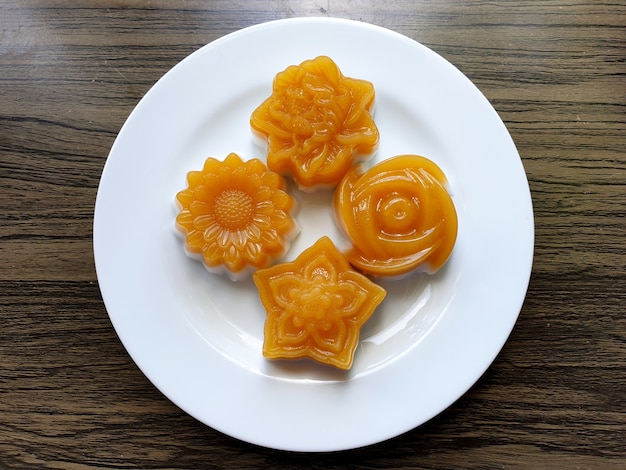 Thai traditional dessert coconut milk jelly flowers on wooden background