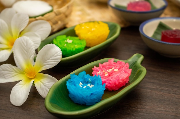 Thai traditional dessert concept Colorful glossy sticky rice on banana leaf plate on wooden table