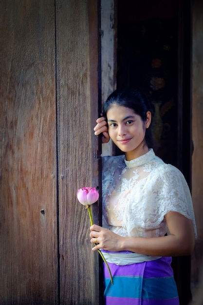 Foto fiore di loto tradizionale tailandese della tenuta della ragazza del vestito a disposizione