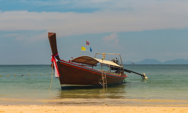 Thai traditional wooden long tail boat And Stone Mountain is located at the beautiful sea. 