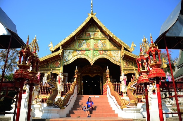 Photo thai travelers women people travel visit respect praying blessing wish myth mystical worship ancient buddha statue of wat ming muang or ming mueang temple on february 24 2015 in chiang rai thailand