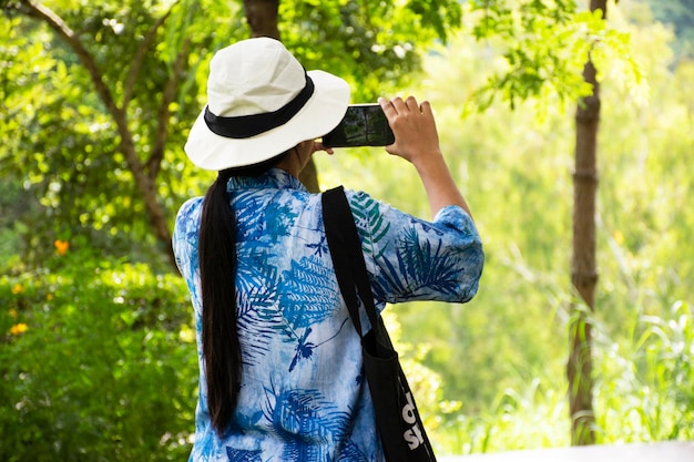 Le donne dei viaggiatori thailandesi viaggiano visitano e utilizzano smartphone o cellulare per scattare foto al punto di vista su phu foi lom nella riserva forestale nazionale di pa phan don nella città di nong saeng a udon thani thailandia
