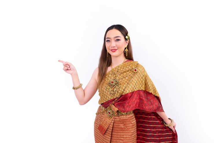 Photo タイの伝統的な衣装を着たタイの女性がタイの文化を宣伝するために手を指さしプレゼンテーションジェスチャーを行い白い背景に隔離されています