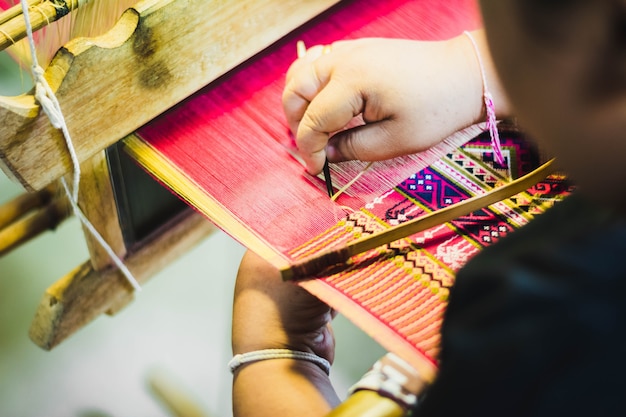 タイの女性が絹の糸を作る。伝統的な手作りのシルク製作方法。