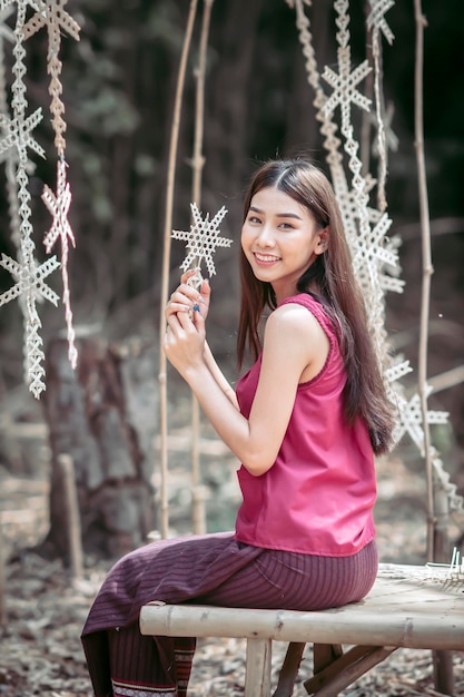 Photo thai woman in rural village clothes is sitting around the house after farming