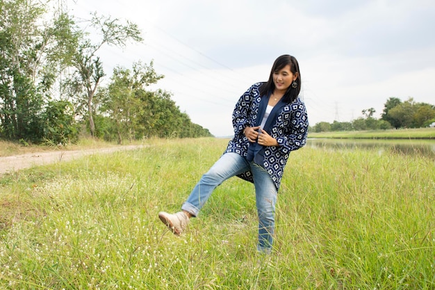 ノンタブリータイの田園地帯で屋外で写真を撮るために肖像画をポーズするファッション藍の服を着ているタイの女性