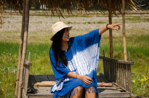 Thai women people travel and posing sit in hut at garden with landscape rice field at Thai Dam Cultural Village in Chiang Khan at Loei Thailand