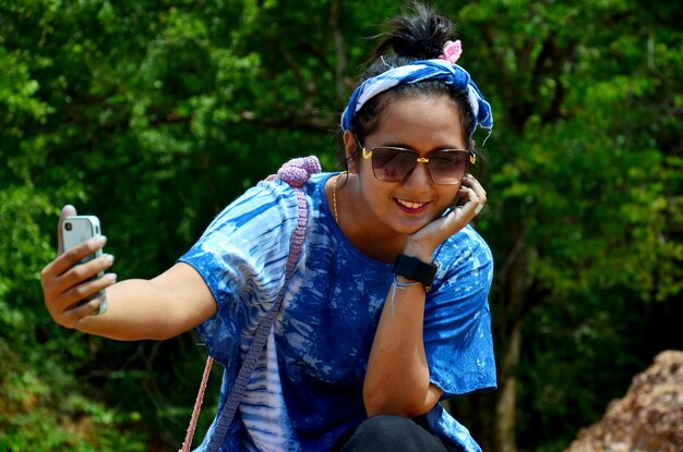 Phrae Thailand의 Pae Mueng Pee Royal Park의 Phae Mueang Phi에서 휴대 전화로 셀카를 찍는 태국 여성