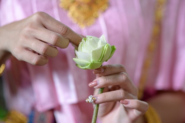 タイの伝統的な衣装を着たタイの女性が花を飾っています。