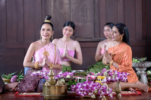 태국 전통 의상을 입은 태국 여성들이 꽃을 장식하고 있습니다.