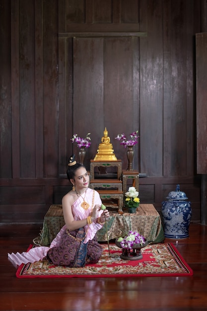 Photo thai women in thai traditional dress are decorating flowers.