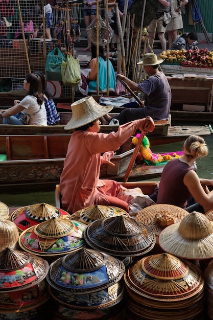 タイ、バンコク: 2007 年 3 月 14 日 - 水上マーケットで販売される観光客とタイの帽子 - 社説