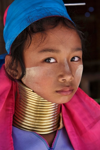 Photo thailand, chiang mai, karen long neck hill tribe village (baan tong lhoung), long neck young girl in traditional costumes. women put brass rings on their neck when they are 5 or 6 years old and increa