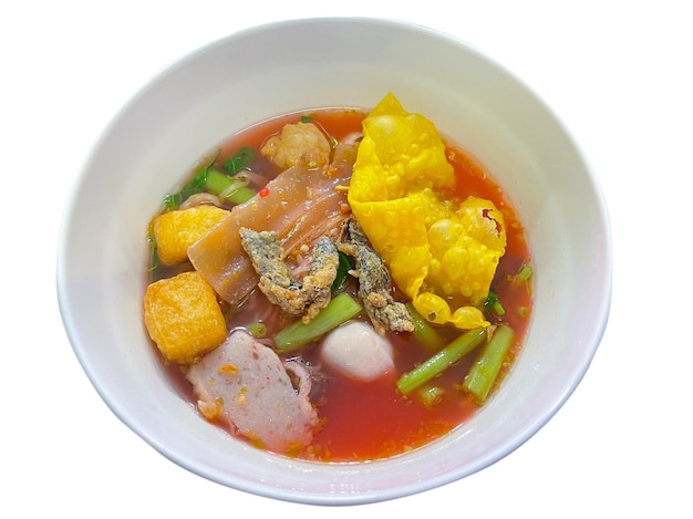 Thailand traditional red tofu sauce noodles served with fish ball fried tofu and other A popular delicious street food of Thai peoples Asian food Shot from above Isolated on white background