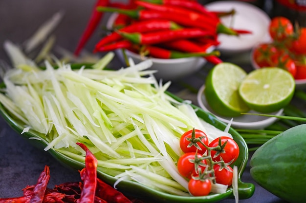 Thais eten bovenaanzicht papajasalade pittig met kruiden en specerijen specerijen en ingrediënten met chili tomaat citroen limoen papaya slice thai food