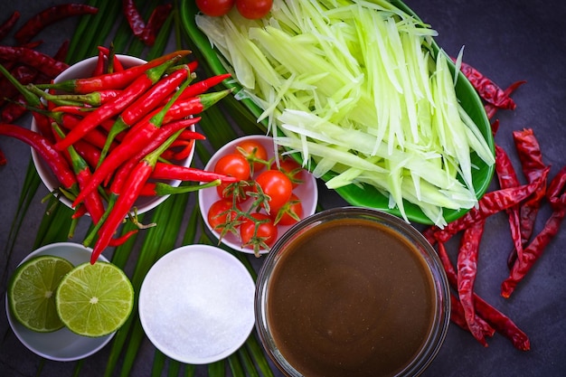 Thais eten bovenaanzicht papajasalade pittig met kruiden en specerijen specerijen en ingrediënten met chili tomaat citroen limoen papaya Slice Thai Food