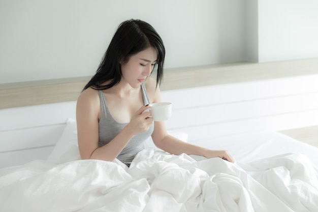 Thais model koffie drinken in de slaapkamer