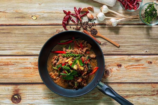 Thais rundvleesroerbak met peper en basilicum op plaat op een donkere stenen achtergrond met kopieerruimte Top