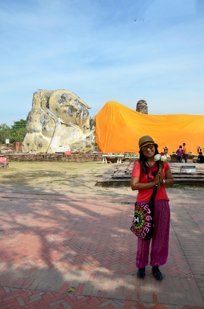 Thais vrouwenportret en bid met de liggende Boeddha van de Wat Lokayasutharam-tempel in Ayutthaya Thailand