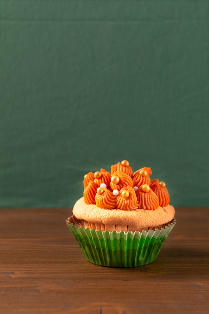 Thaise ijsthee cupcake op houten raad en groene achtergrond met exemplaarruimte