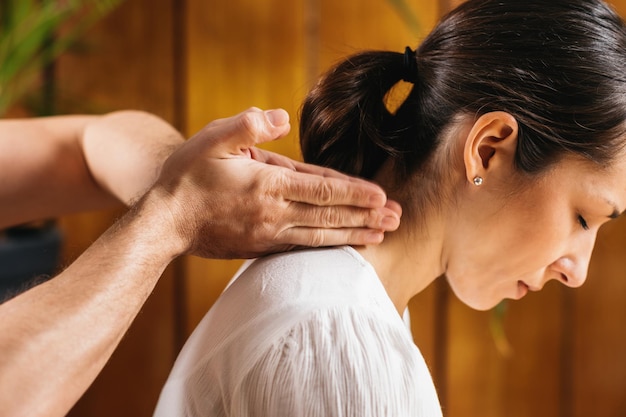 Foto thaise massage - rugpijnverlichting masseur met behulp van thaise massage techniek met de handen