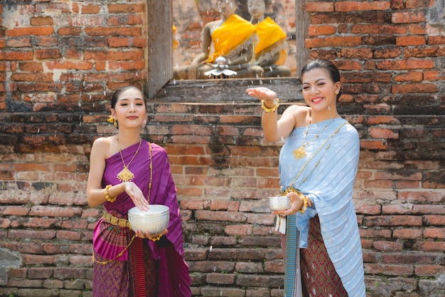 Thaise meisjes in thais traditioneel kledings bespattend water tijdens festival songkran festival, ayutthaya, thailand.