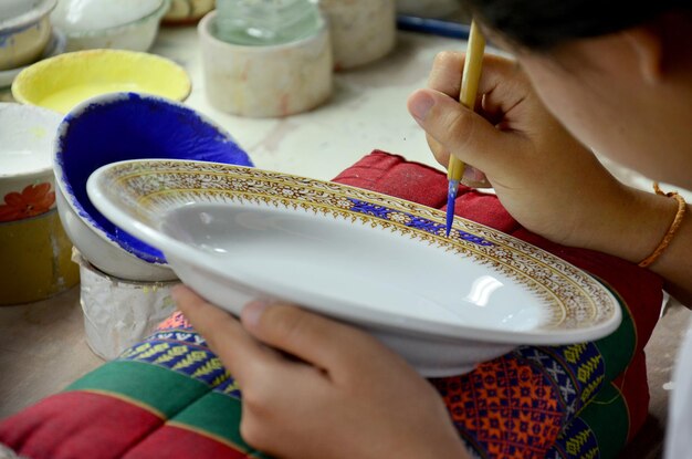 Thaise mensen die procesverf maken Keramische Benjarong is traditioneel Thais aardewerk in vijf basiskleuren