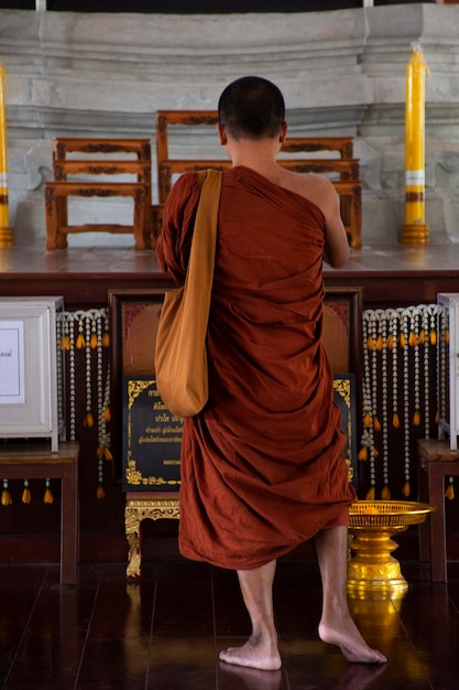 Thaise monniken, mensen reizen, bezoeken archeologie en betalen respect biddend oud antiek Boeddhabeeld in Wat Phu Khao Thong of Phukhao Thong tempel op 6 november 2022 in Phra Nakhon Si Ayutthaya, Thailand