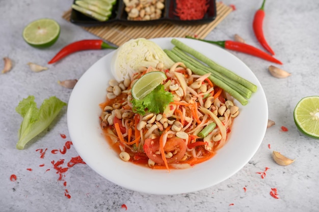 Thaise papajasalade in een witte plaat met chili limoen en knoflook