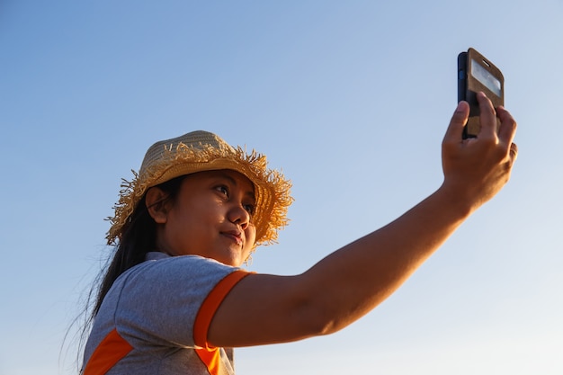 Thaise vrouw met behulp van de smartphone op het strand