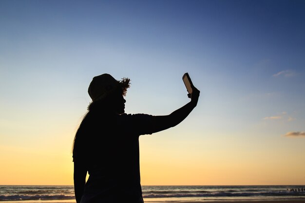 Thaise vrouw met behulp van de smartphone op het strand