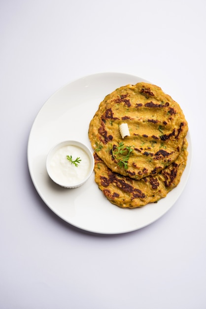 Thalipeeth is een soort hartige meergranenpannenkoek die populair is in Maharashtra, India, geserveerd met wrongel, boter of ghee