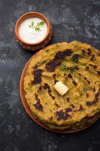 Thalipeeth is een soort hartige meergranenpannenkoek die populair is in Maharashtra, India, geserveerd met wrongel, boter of ghee