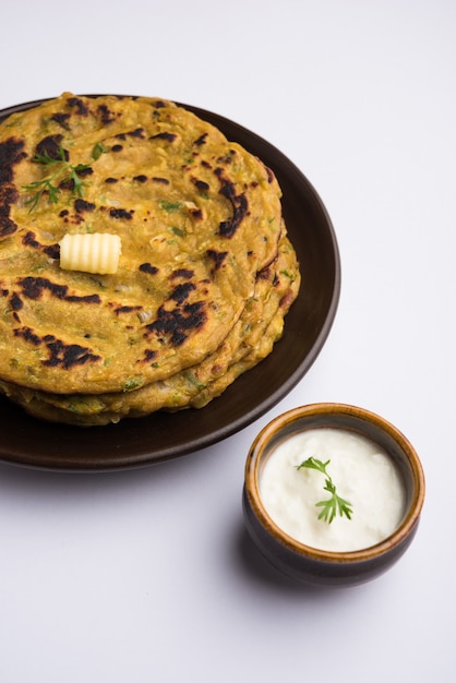 Thalipeeth는 인도 마하라슈트라에서 인기 있는 짭짤한 잡곡 팬케이크의 일종으로 두부, 버터 또는 버터 기름이 함께 제공됩니다.