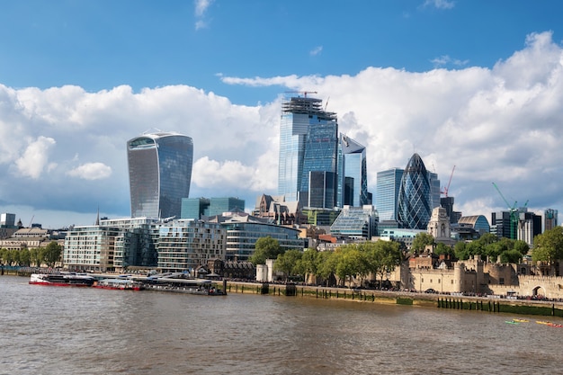 Thames river and London city financial district skyscrapers on a sunny day.