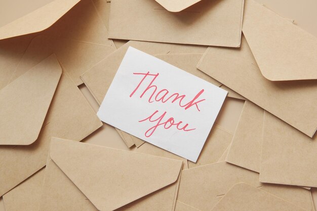 thank you message and envelope on wooden table