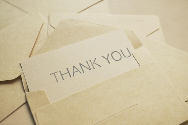 Thank you message and envelope on wooden table