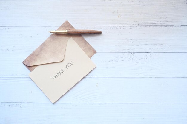 Photo thank you message and envelope on wooden table