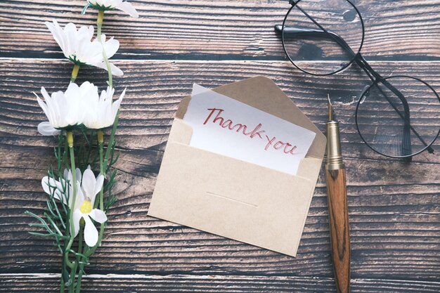 Photo thank you message and envelope on wooden table