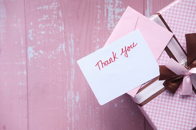 Photo thank you message and gift box on pink space .