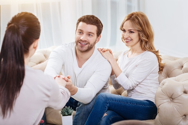 Thank you. Nice handsome joyful man holding the psychologists hand and smiling while being thankful for hel