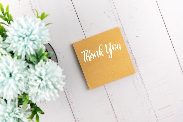 Thank you note on adhesive note with flower flat lay