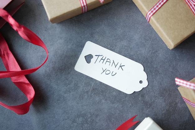 Thank you note and gift box on black background