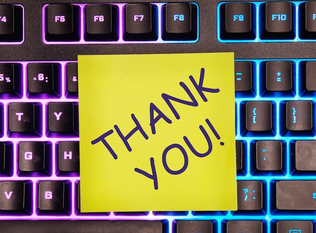 The thank you text written on a yellow sticker left on the laptop keyboard