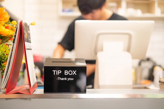 Thank you word on Black Tip box for good service on cashier counter in coffee shopTips is a sum of money customarily given by a client or customer to a service worker in addition to the basic price