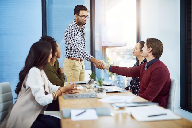 thank you for your commitment to excellence shot of a businessman shaking his colleagues hand in a meeting