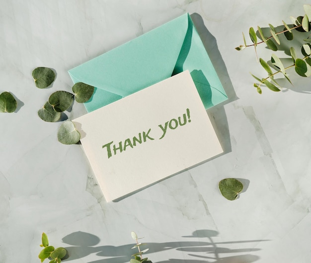 Thank yoy card and mint green envelope. Fresh eucalyptus twigs and leaves.