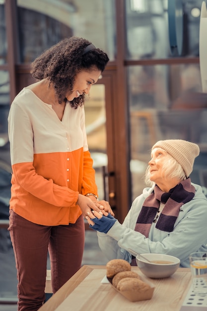 Photo thanks for help. delighted aged woman smiling while feeling kindness of people