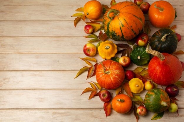 Thanksgiving-arrangement met rode, groene, oranje, gestreepte pompoenen, herfstbladeren, gele pompoenen op de witte houten tafel, kopieerruimte